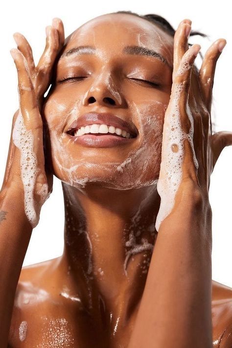 A woman gently cleansing her face